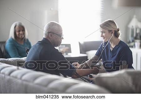 Nurse taking patient blood pressure in living room View Large Photo Image Stock Photography - Nurse taking patient blood pressure in living room. Fotosearch