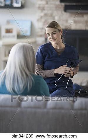 Nurse talking to patient in living room View Large Photo Image Stock Photo - Nurse talking to patient in living room. Fotosearch