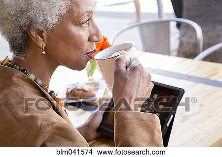 Picture - Older African American woman drinking coffee. Fotosearch