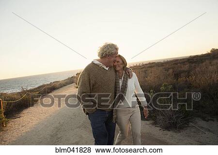 Stock Photo - Older Caucasian couple walking on dirt path. Fotosearch