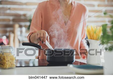 Older Caucasian woman cooking in kitchen View Large Photo Image Stock Photo - Older Caucasian woman cooking in kitchen. Fotosearch