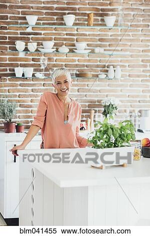 Older Caucasian woman smiling in kitchen View Large Photo Image Stock Photography - Older Caucasian woman smiling in kitchen. Fotosearch