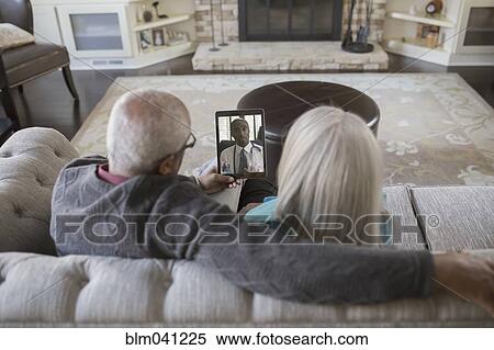 Stock Photography - Older couple video chatting with digital tablet. Fotosearch