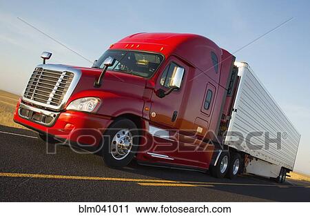 Stock Image - Truck driving on remote road. Fotosearch