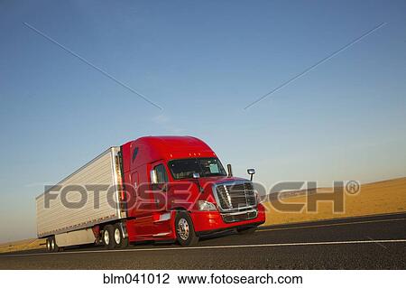 Stock Image - Truck driving on remote road. Fotosearch