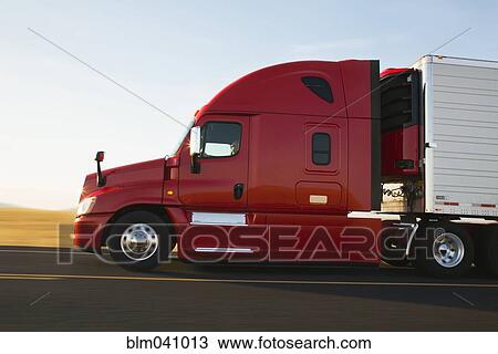 Stock Image - Truck driving on remote road. Fotosearch