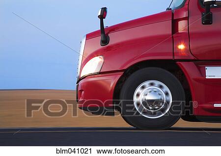 Stock Image - Truck driving on remote road. Fotosearch