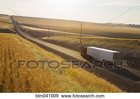 Stock Photo - Truck driving on remote road. Fotosearch