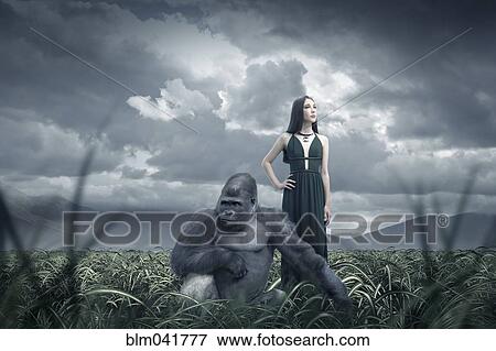 Stock Photo - Woman and gorilla in remote field. Fotosearch