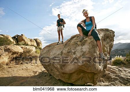 Stock Photo - Women standing on rock formation. Fotosearch