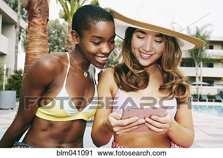 Stock Image - Women using digital tablet outdoors. Fotosearch