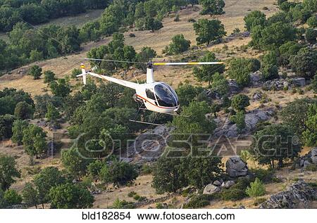 Picture - Aerial view of helicopter flying over remote landscape. Fotosearch