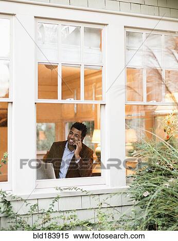 Stock Photography - African American businessman talking on cell phone in office. Fotosearch