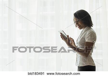 Stock Image - African American businesswoman using digital tablet. Fotosearch