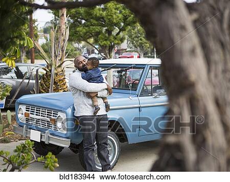 Picture - African American father holding son at truck. Fotosearch