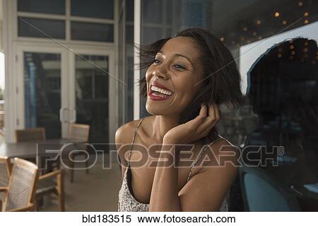 Stock Photography - African American woman laughing in restaurant. Fotosearch