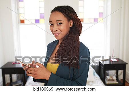 African American woman using cell phone in bedroom View Large Photo Image Stock Photo - African American woman using cell phone in bedroom. Fotosearch