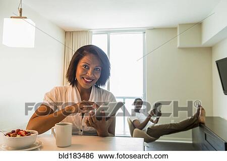 Stock Photograph - African American woman using digital tablet. Fotosearch