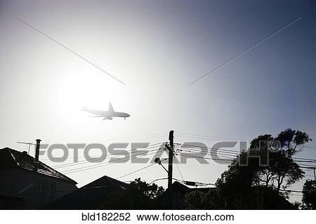 Airplane flying over neighborhood rooftops View Large Photo Image Stock Image - Airplane flying over neighborhood rooftops. Fotosearch