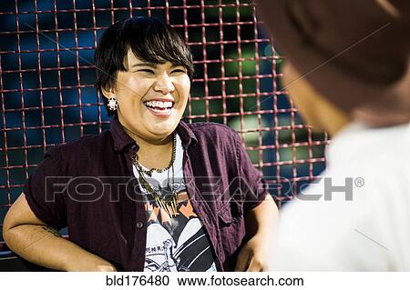 Stock Image - Asian couple talking outdoors. Fotosearch