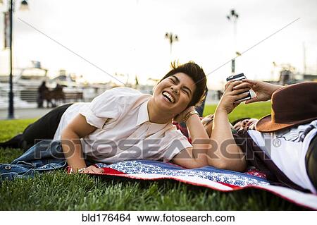 Asian friends laying in grass View Large Photo Image Picture - Asian friends laying in grass. Fotosearch