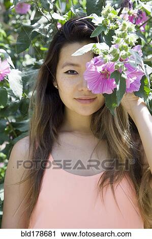 Asian woman hiding behind flower View Large Photo Image Stock Image - Asian woman hiding behind flower. Fotosearch