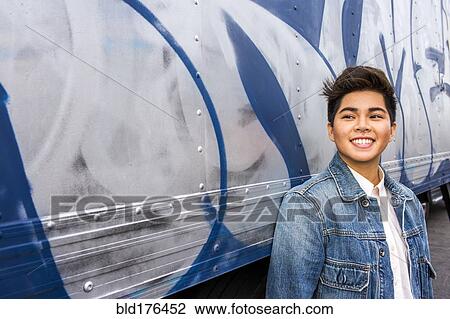 Asian woman smiling at graffiti wall View Large Photo Image Stock Image - Asian woman smiling at graffiti wall. Fotosearch