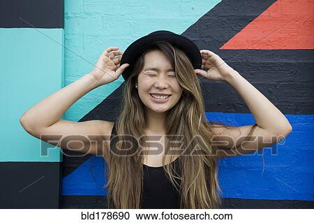 Stock Image - Asian woman smiling with eyes closed. Fotosearch