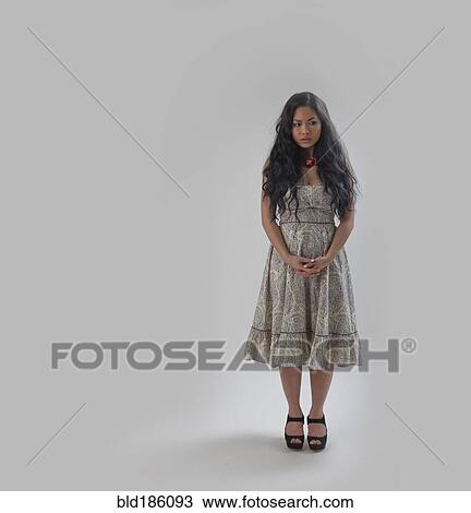 Asian woman standing with hands clasped View Large Photo Image Stock Image - Asian woman standing with hands clasped. Fotosearch