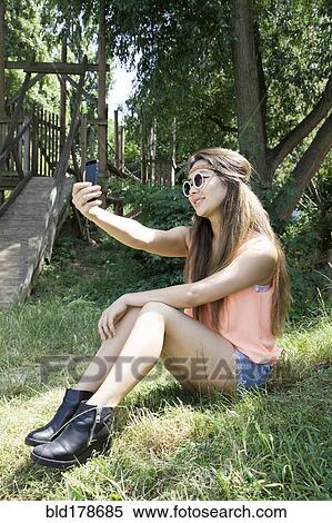 Stock Photography - Asian woman taking selfie outdoors. Fotosearch