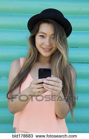 Stock Image - Asian woman using cell phone. Fotosearch