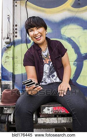 Stock Photography - Asian woman using cell phone. Fotosearch