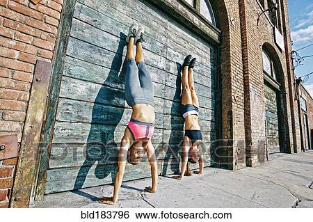 Athletes doing handstand on sidewalk View Large Photo Image Stock Photograph - Athletes doing handstand on sidewalk. Fotosearch