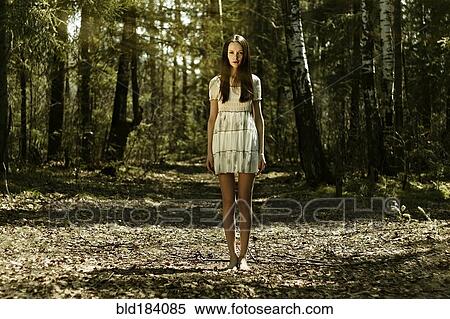 Stock Photography - Barefoot Caucasian woman standing in forest. Fotosearch