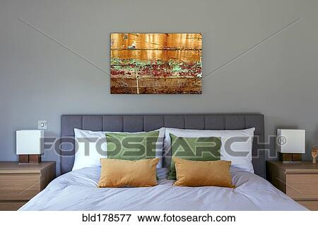 Stock Photo - Bed and wall art in modern bedroom. Fotosearch