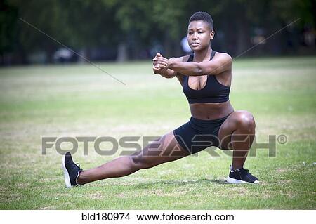 Picture - Black athlete stretching in park. Fotosearch