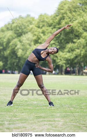Stock Photography - Black athlete stretching in park. Fotosearch