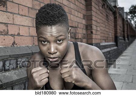 Stock Image - Black athlete with fists raised outdoors. Fotosearch