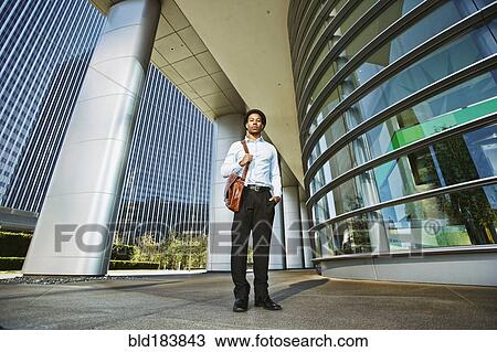 Black businessman standing outside office building View Large Photo Image Stock Image - Black businessman standing outside office building. Fotosearch