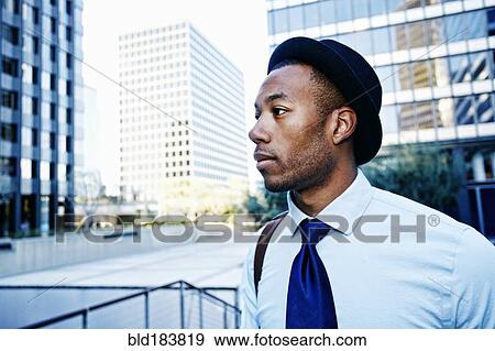 Stock Photo - Black businessman standing outside office building. Fotosearch