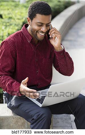 Black businessman talking on cell phone outdoors View Large Photo Image Stock Image - Black businessman talking on cell phone outdoors. Fotosearch