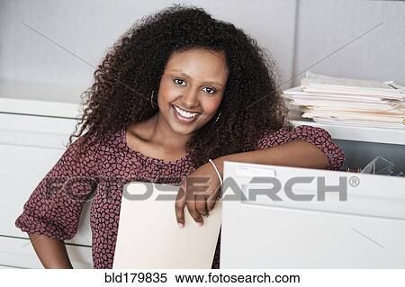 Black businesswoman smiling in office View Large Photo Image Stock Photography - Black businesswoman smiling in office. Fotosearch