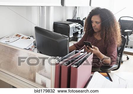Stock Image - Black businesswoman working at office desk. Fotosearch