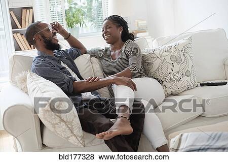 Stock Photo - Black couple talking on sofa. Fotosearch