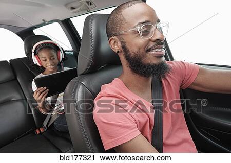 Stock Image - Black father and daughter driving in car. Fotosearch