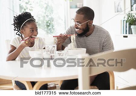 Black father and daughter eating noodles View Large Photo Image Stock Photography - Black father and daughter eating noodles. Fotosearch