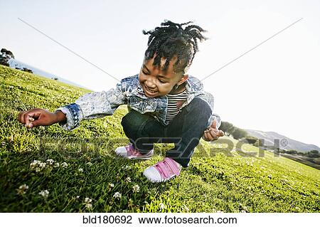 Black girl picking flowers in field View Large Photo Image Stock Image - Black girl picking flowers in field. Fotosearch