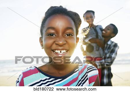 Stock Image - Black girl smiling on beach. Fotosearch