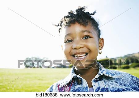 Stock Photo - Black girl smiling outdoors. Fotosearch
