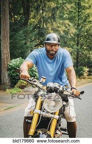 Black man sitting on motorcycle View Large Photo Image Stock Image - Black man sitting on motorcycle. Fotosearch